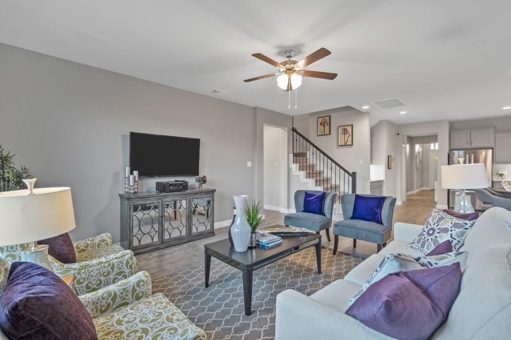 130 Hugo Court Rhome, TX 76078 - Photo 16 of 40 a living room with furniture a flat screen tv and a chandelier