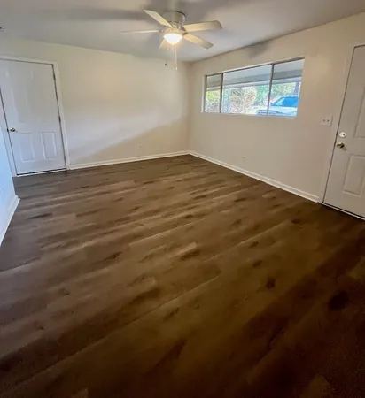 an empty room with wooden floor and windows
