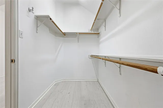a view of walk in closet with empty racks