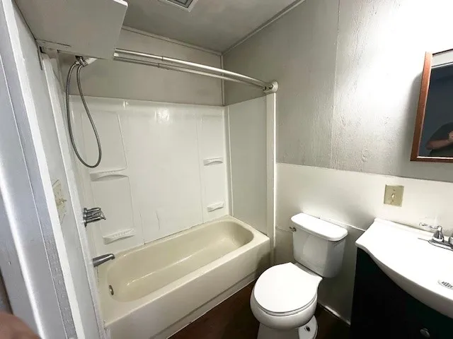 a white toilet sitting next to a bath tub and shower