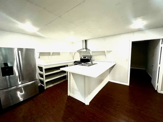 a kitchen with a sink stainless steel appliances and wooden floor