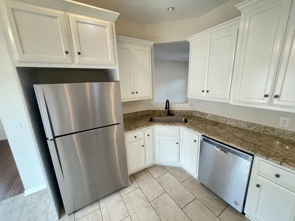 a kitchen with white cabinets and white appliances