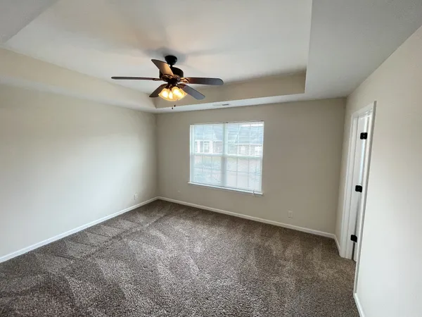 a view of empty room with wooden floor and ceiling fan
