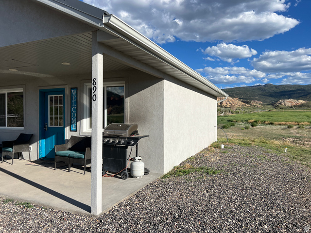 890 East Hatchery Road Bicknell, UT 84715 - Photo 4 of 48 View of property exterior featuring stucco siding, a mountain view, and a porch