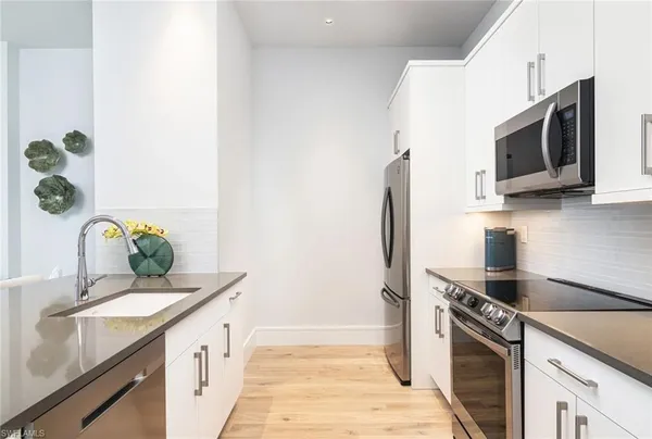 a kitchen with stainless steel appliances granite countertop a sink stove and microwave