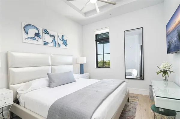 a bedroom with a large bed and a potted plant