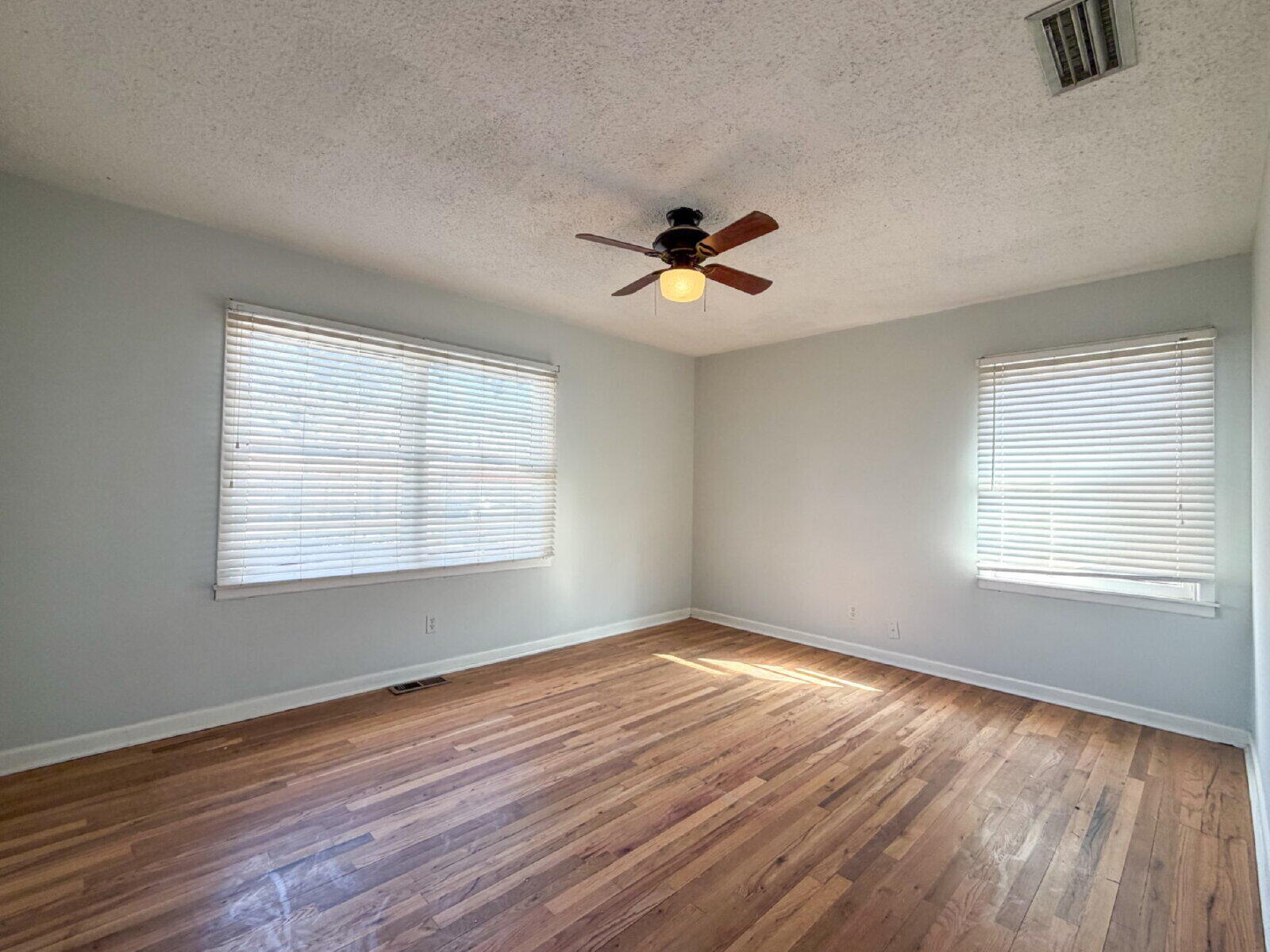 3415 35th Street Lubbock, TX 79413 - Photo 7 of 11 a view of empty room with wooden floor and fan