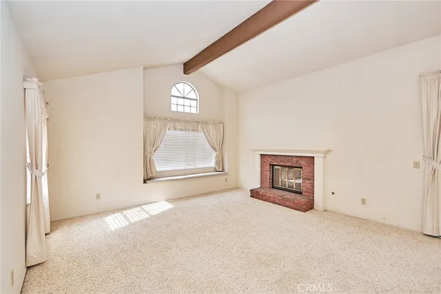 an empty room with windows and fireplace