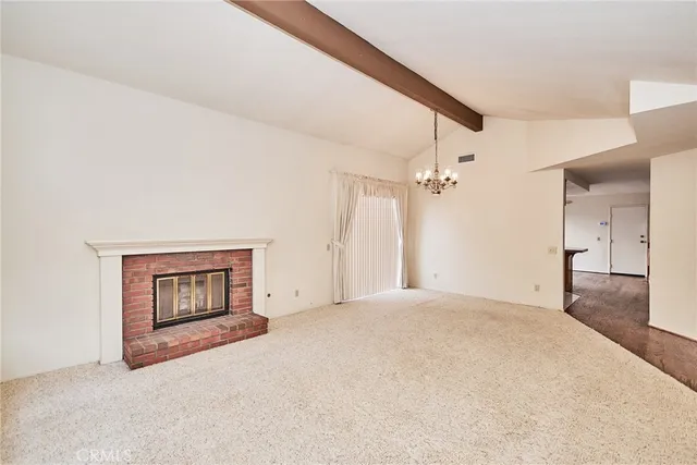 a view of an empty room with a fireplace and a window