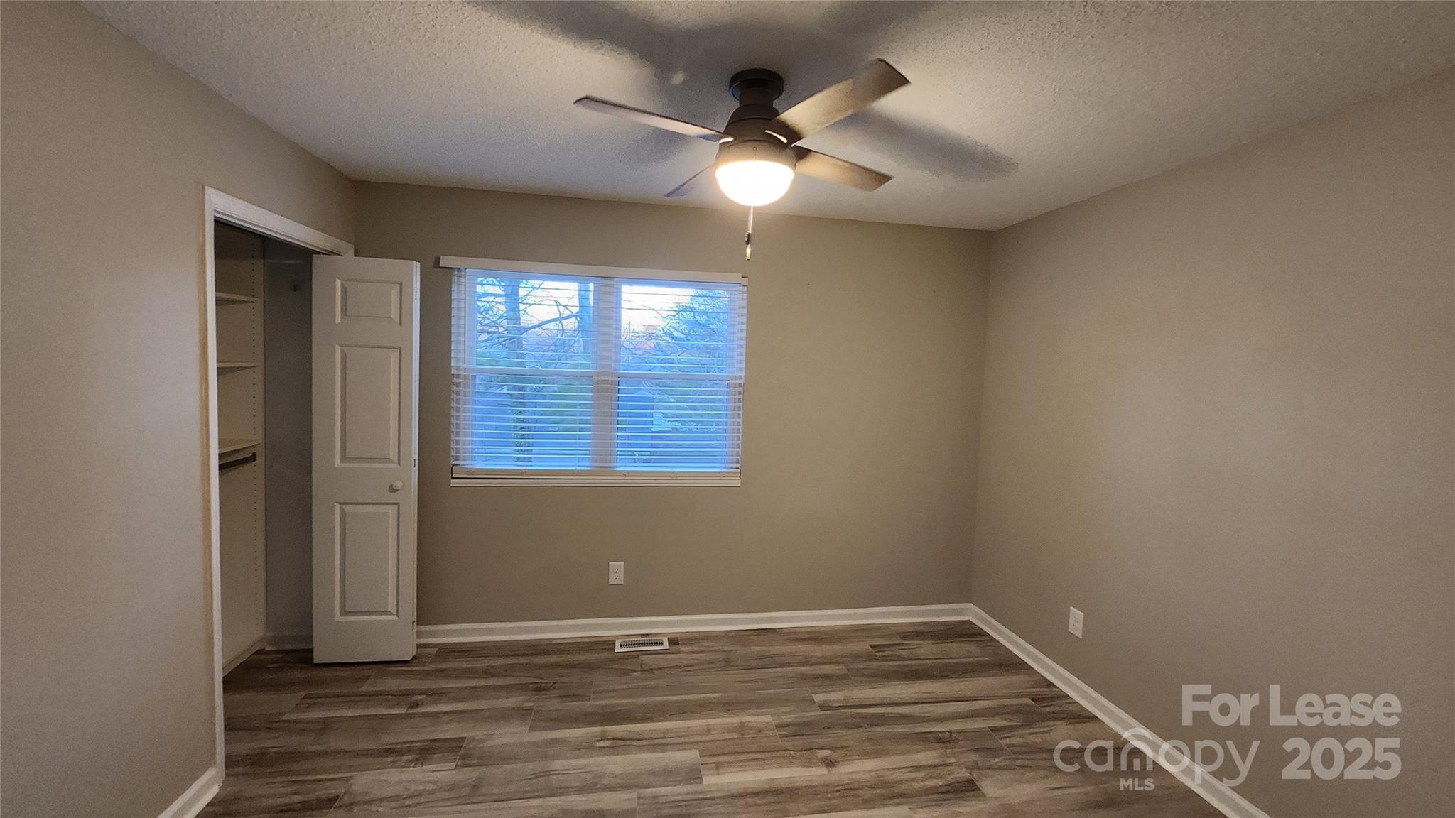 7505 Sarah Drive Denver, NC 28037 - Photo 11 of 13 an empty room with wooden floor and windows
