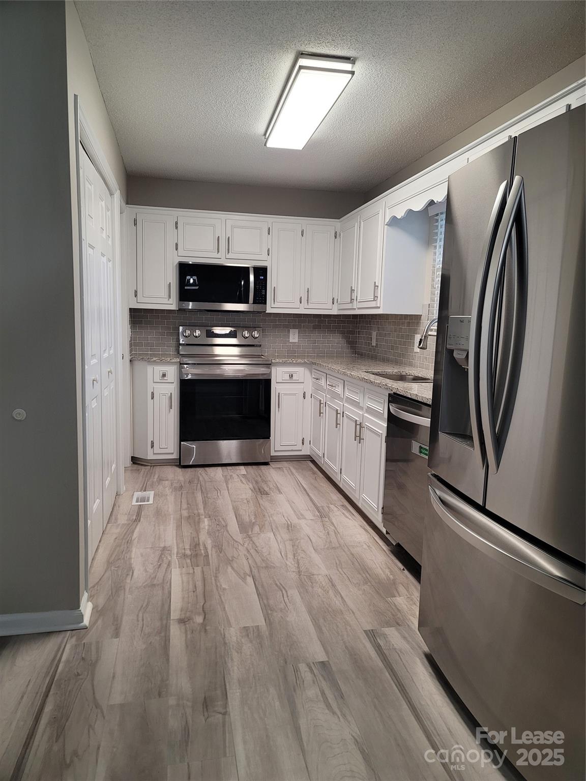 7505 Sarah Drive Denver, NC 28037 - Photo 5 of 13 a kitchen with stainless steel appliances granite countertop a refrigerator sink and stove