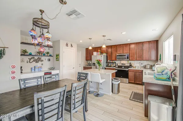 a kitchen with kitchen island a stove a table and chairs in it