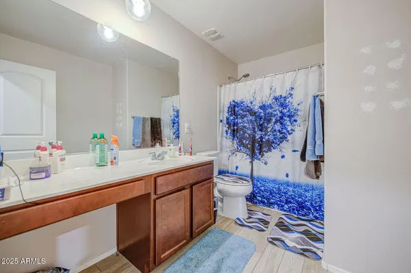 a bathroom with a sink mirror and a toilet