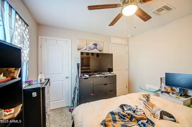 a bedroom with a bed and a flat screen tv