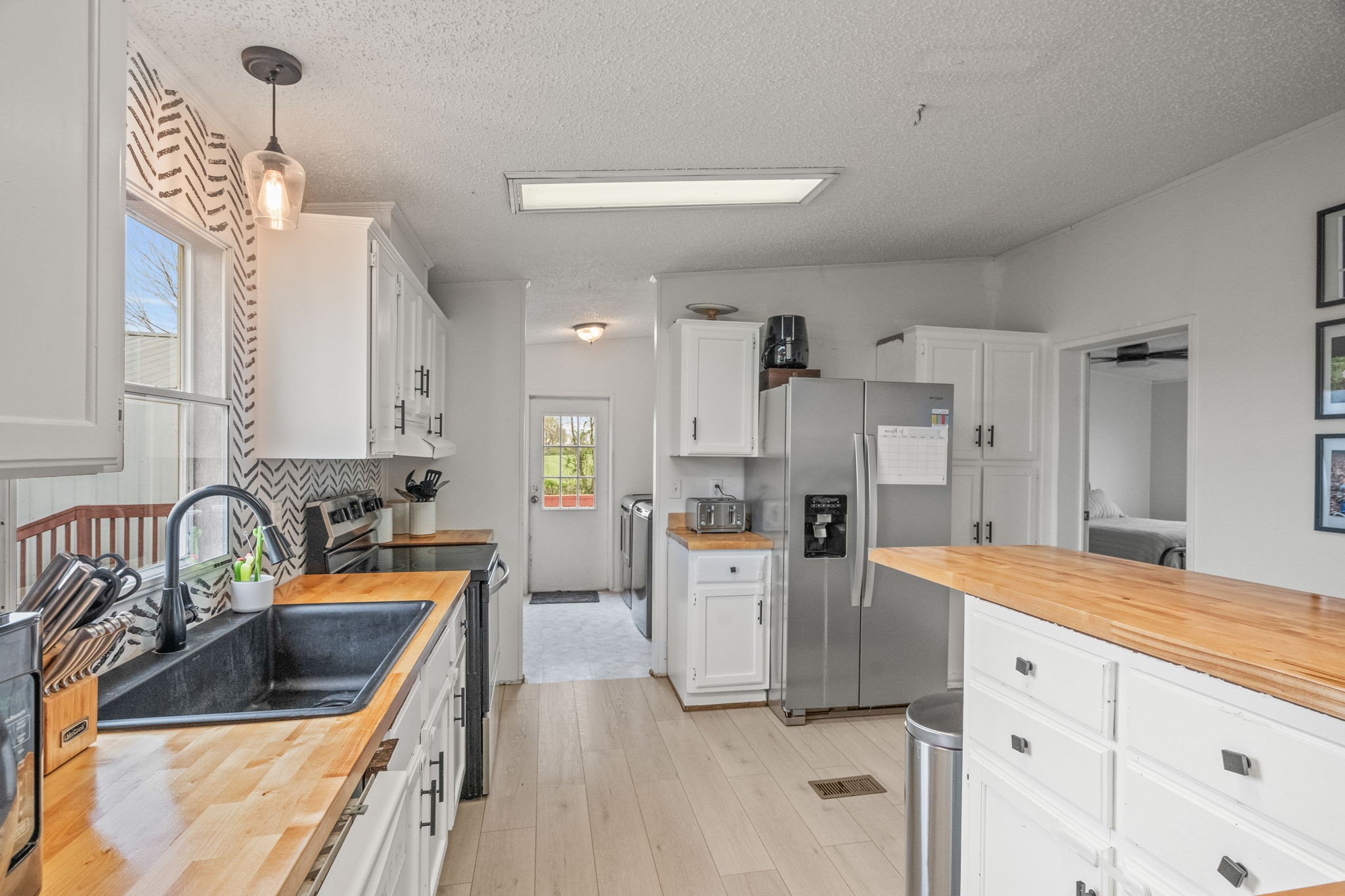 1848 Mint Springs Road Adams, TN 37010 - Photo 15 of 36 a kitchen with white cabinets and stainless steel appliances