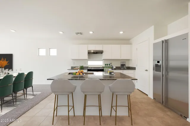 a kitchen with stainless steel appliances granite countertop a stove a sink a refrigerator and a refrigerator