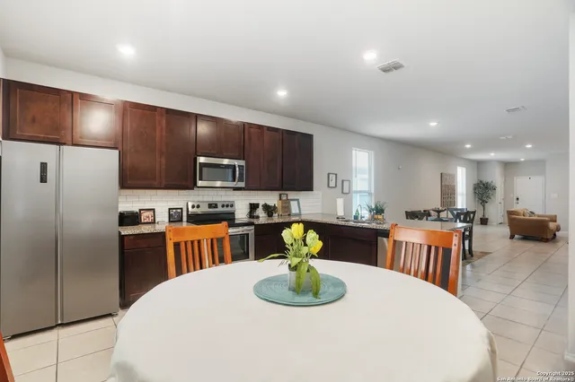 a kitchen with stainless steel appliances wooden floor dining table and chairs