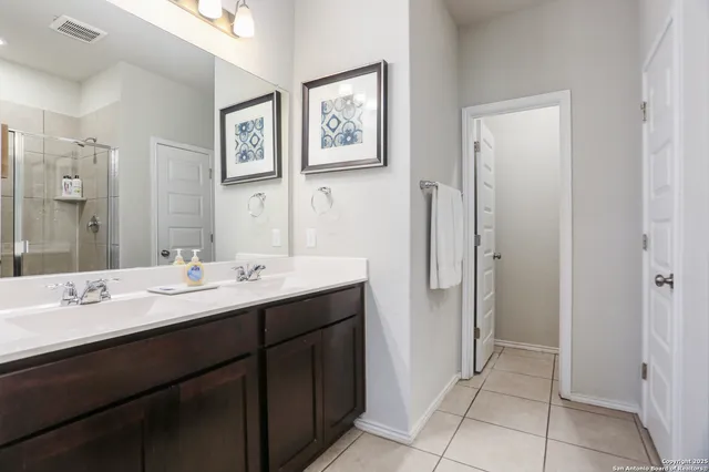 a bathroom with a double vanity sink mirror and toilet