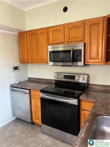 a kitchen with granite countertop a stove and a microwave