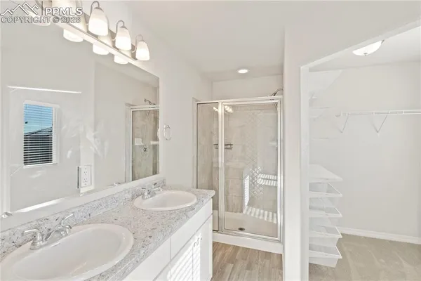 a bathroom with a granite countertop sink a large mirror and a shower