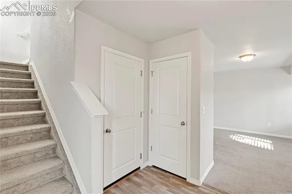 a view of a hallway with wooden floor and entryway