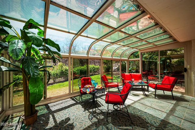 a living room with red red furniture and floor to ceiling window