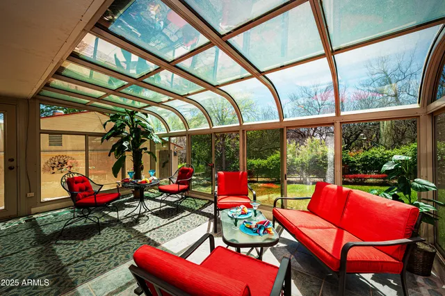 a living room with patio furniture and a floor to ceiling window