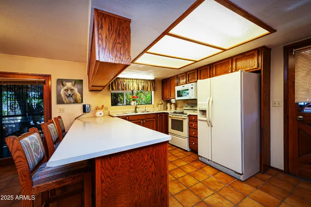a kitchen with stainless steel appliances kitchen island granite countertop dining table and chairs