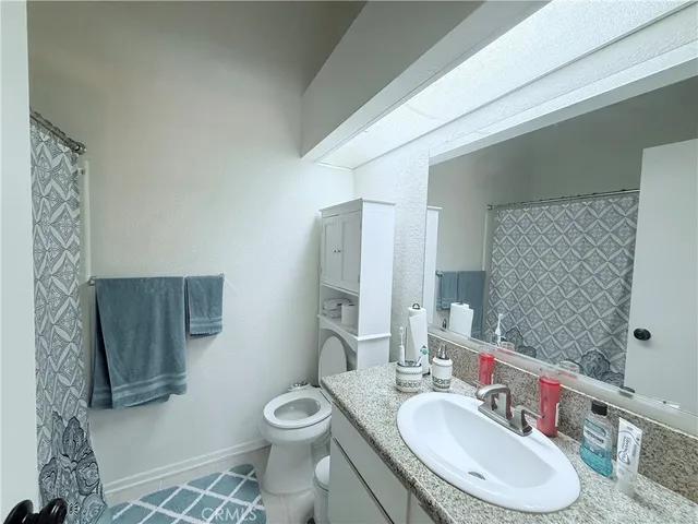 a bathroom with a sink toilet a mirror and shower