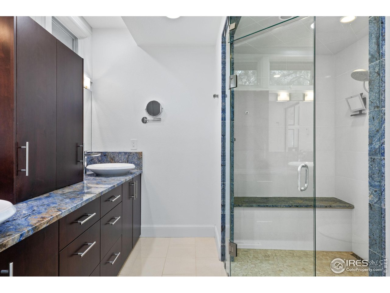 8543 Middle Fork Road Boulder, CO 80302 - Photo 31 of 48 a bathroom with a granite countertop sink a mirror and shower