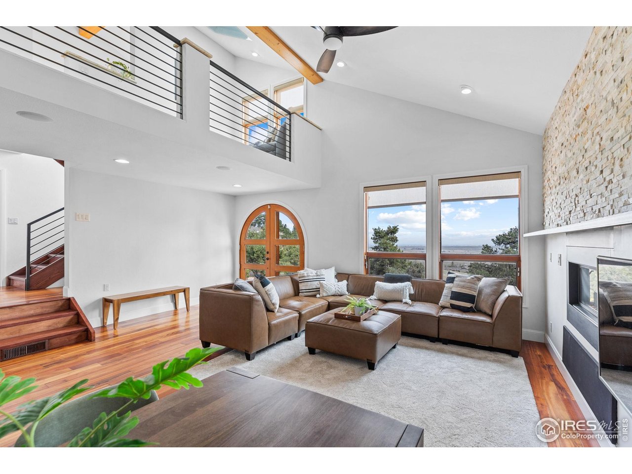 8543 Middle Fork Road Boulder, CO 80302 - Photo 9 of 48 a living room with furniture a fireplace a rug potted plant and a large window