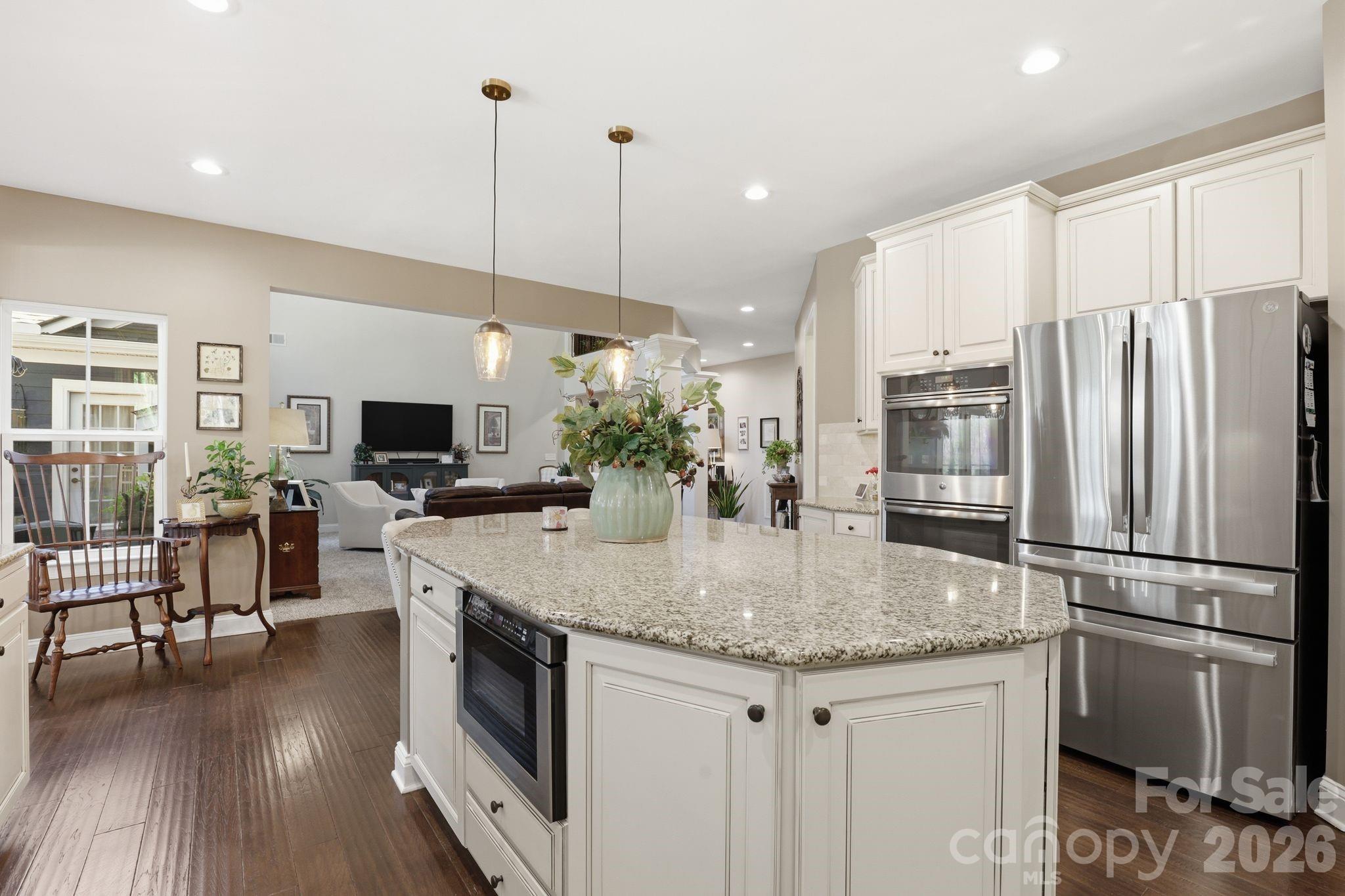 215 Streamwood Road Troutman, NC 28166 - Photo 19 of 48 a kitchen with stainless steel appliances granite countertop a kitchen island hardwood floor and a sink