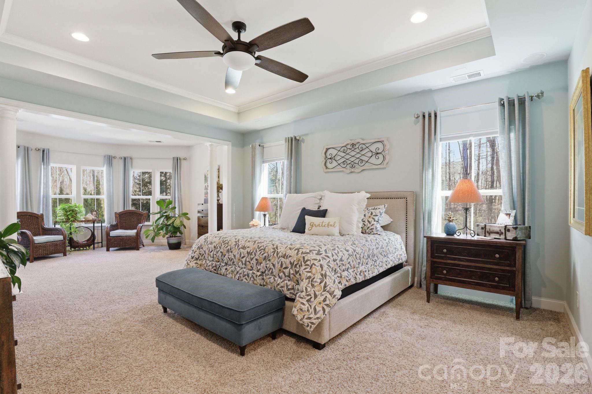 215 Streamwood Road Troutman, NC 28166 - Photo 21 of 48 a spacious bedroom with a bed a couch and a ceiling fan