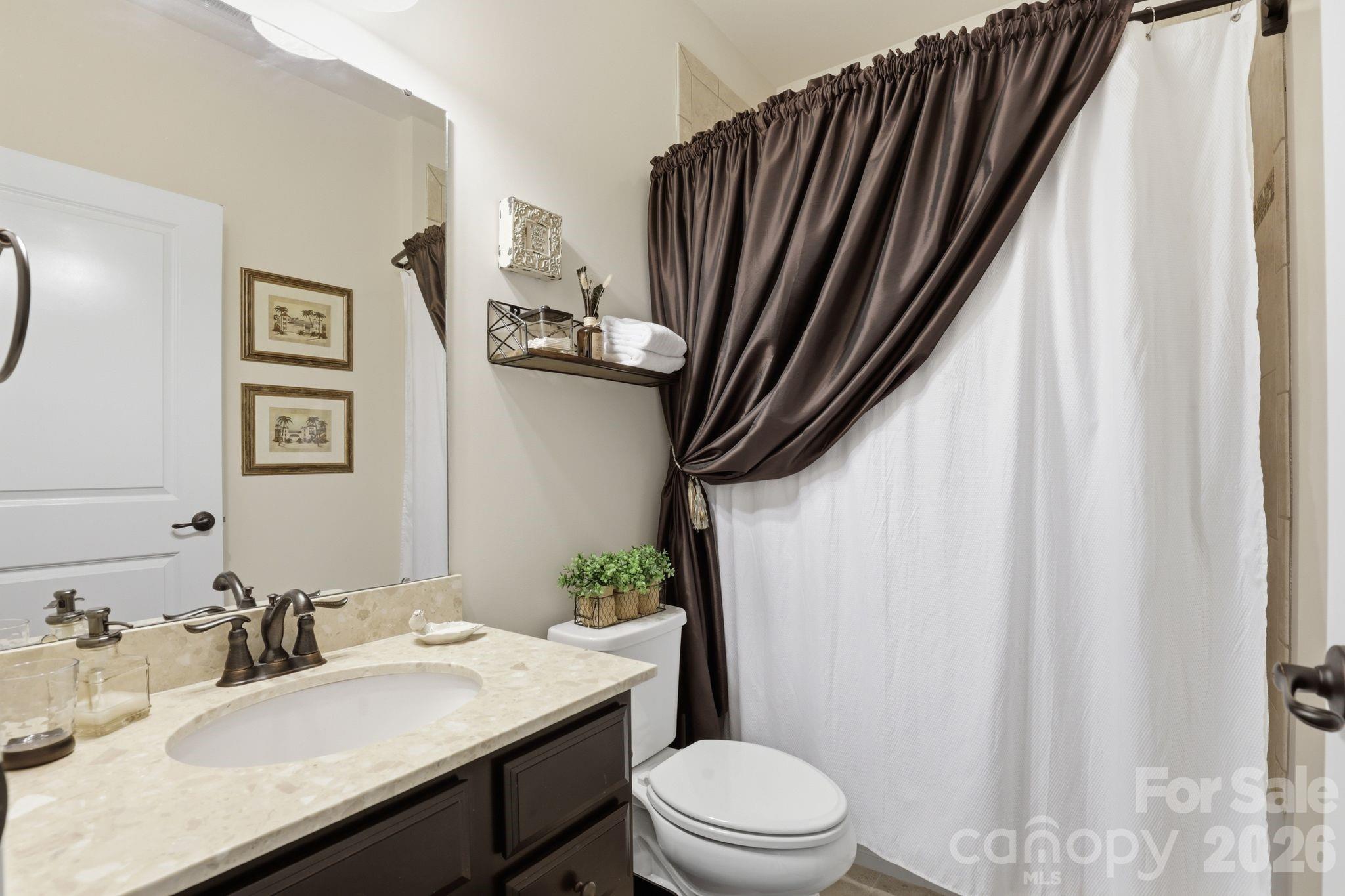 215 Streamwood Road Troutman, NC 28166 - Photo 33 of 48 a bathroom with a granite countertop sink toilet and a mirror