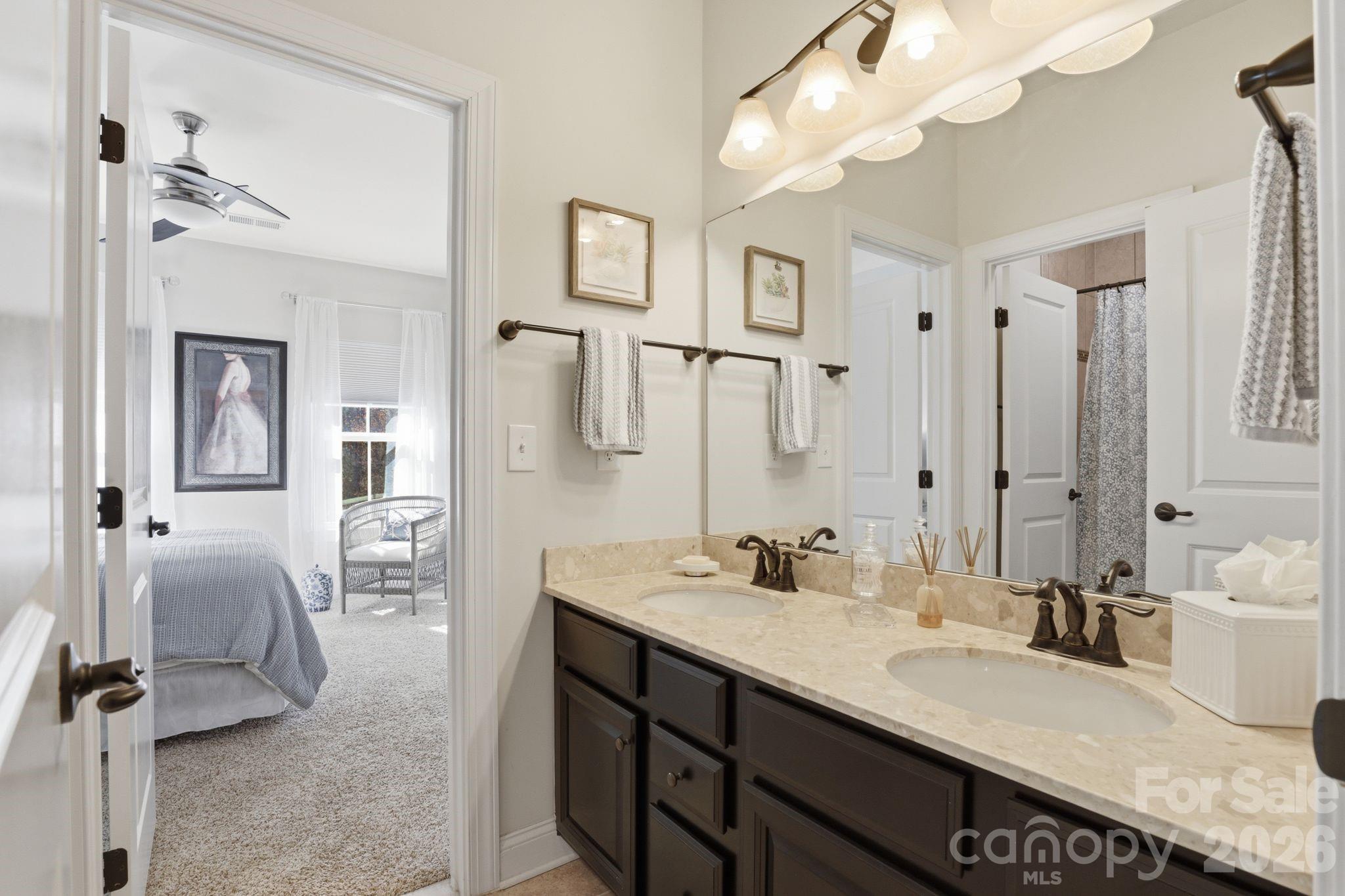 215 Streamwood Road Troutman, NC 28166 - Photo 36 of 48 a bathroom with double vanity sinks a vanity two mirror and a shower