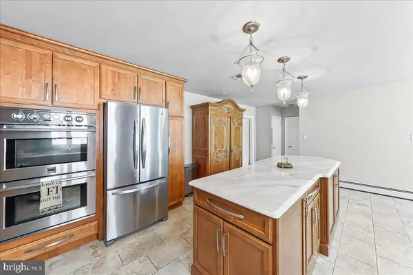a large kitchen with kitchen island a sink and a refrigerator