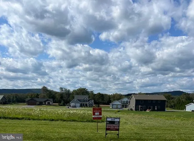 a view of a big yard with a house in the background