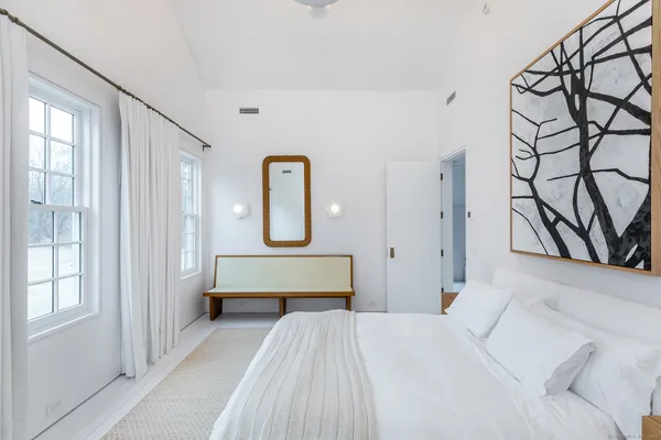 a bedroom with a large bed and a window