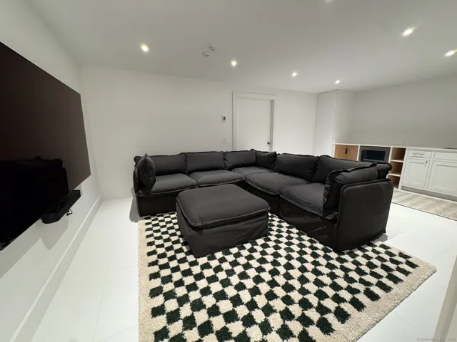 a living room with a couch and a black white checkered floor