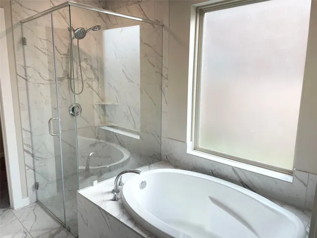 a bathroom with a tub and shower