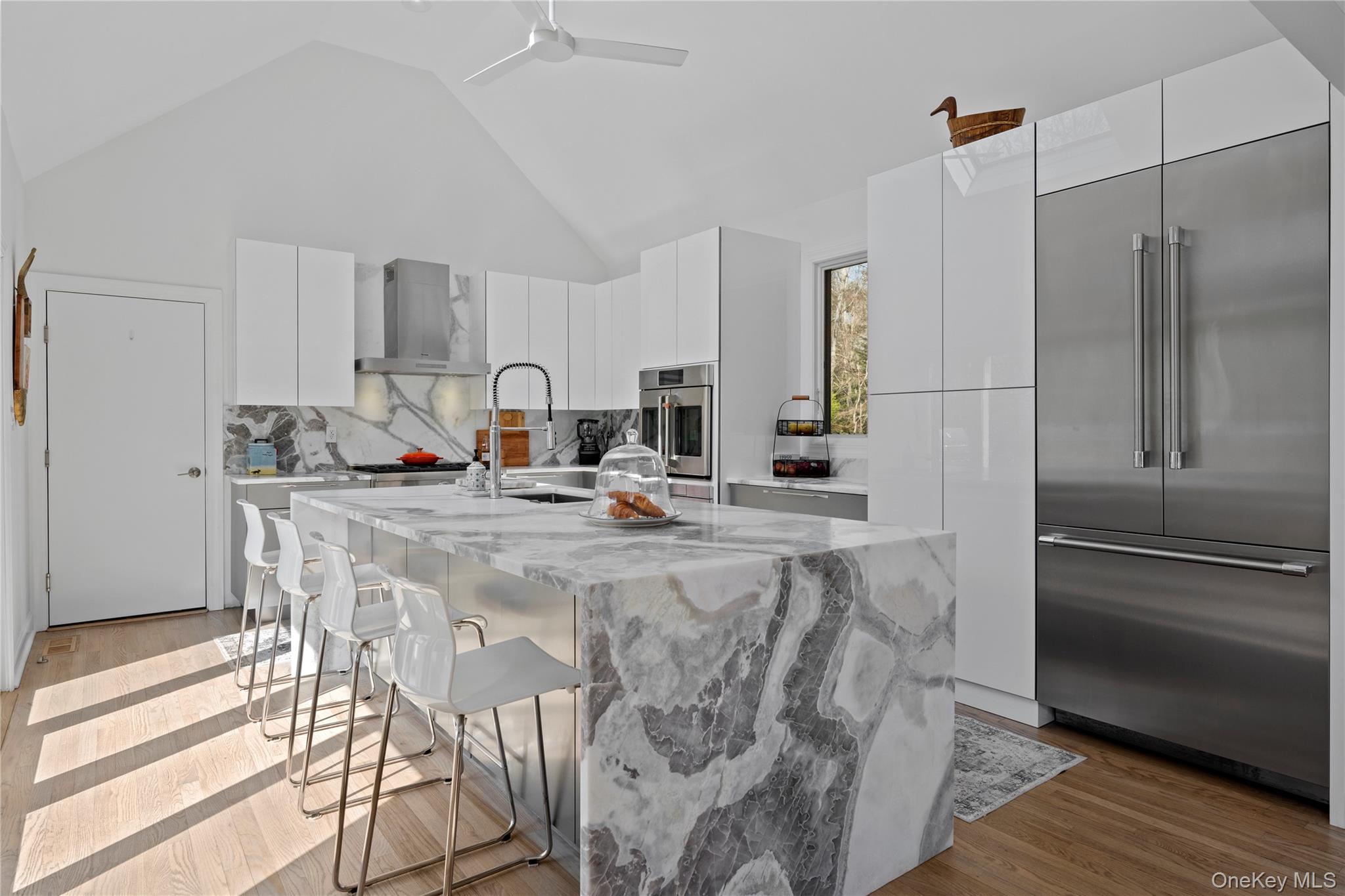38 Pheasant Run Quogue, NY 11959 - Photo 11 of 35 a kitchen with stainless steel appliances kitchen island granite countertop a refrigerator a stove and white cabinets with wooden floor