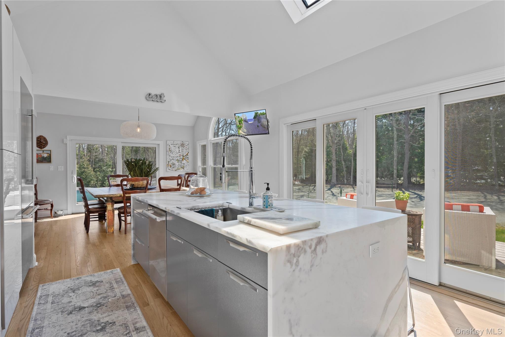 38 Pheasant Run Quogue, NY 11959 - Photo 12 of 35 a dining hall with couches a flat tv screen and a dining table with garden view