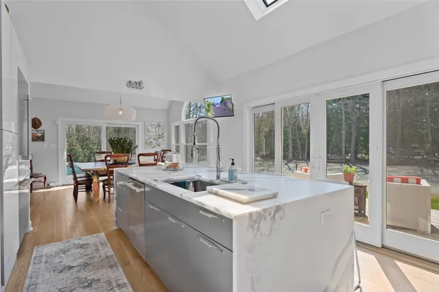 a dining hall with couches a flat tv screen and a dining table with garden view