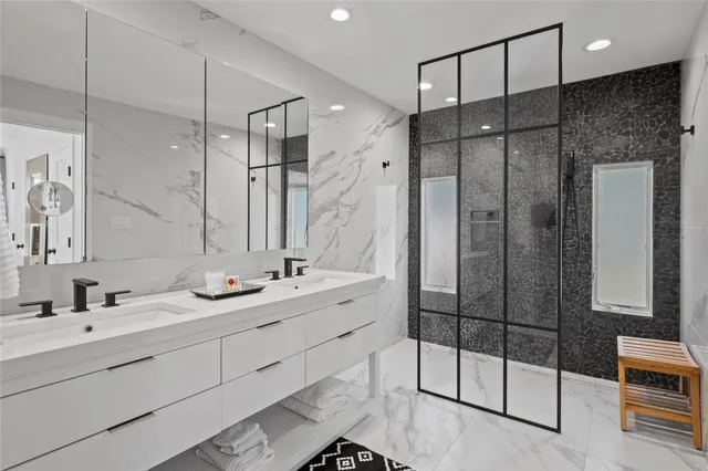 a bathroom with a double vanity sink mirror and shower