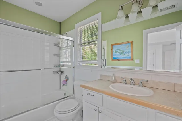 a bathroom with a granite countertop sink toilet a large mirror and shower