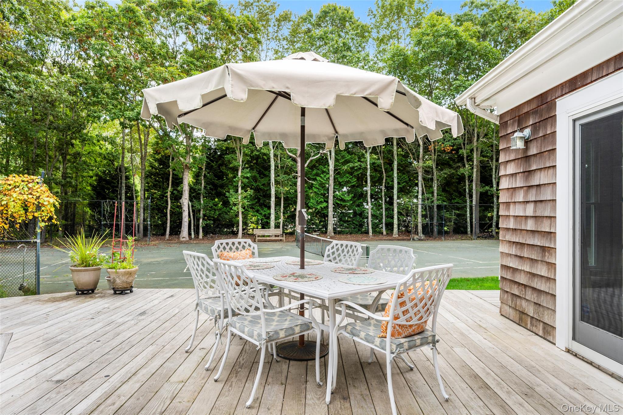 38 Pheasant Run Quogue, NY 11959 - Photo 34 of 35 a view of a wooden chairs and table in the patio in front of a house