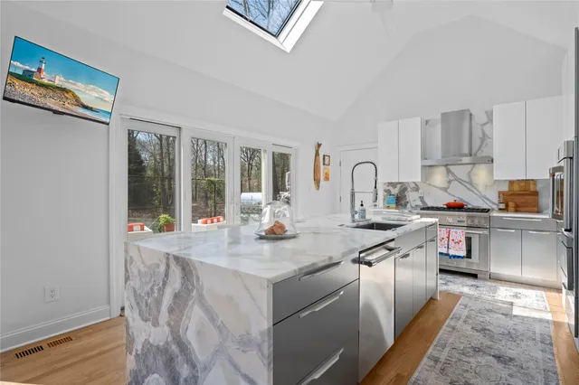 a kitchen with stainless steel appliances granite countertop a sink and a stove