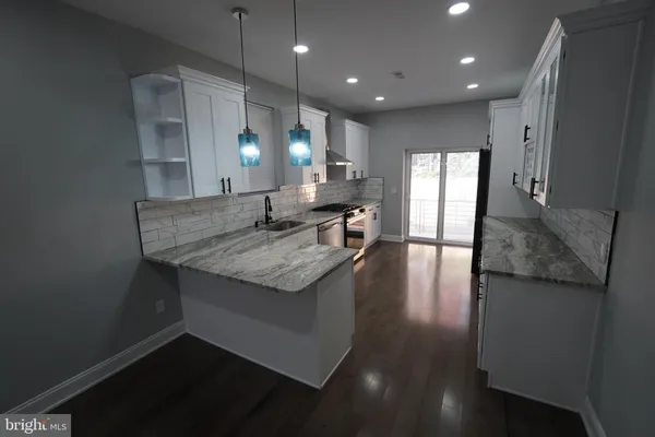 a kitchen with granite countertop sink stove and cabinets