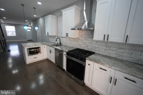 a kitchen with granite countertop stainless steel appliances and wooden cabinets