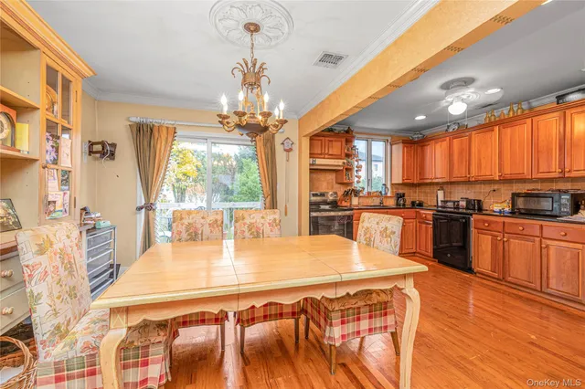 a kitchen with stainless steel appliances wooden floors wooden cabinets a center island and windows